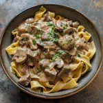 Creamy Dijon beef stroganoff served with mushrooms and pasta in a bowl