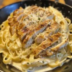 Creamy restaurant-style chicken alfredo pasta in a white bowl garnished with parsley